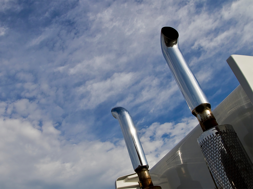 A photograph of a truck's exhaust pipes pointing skyward.