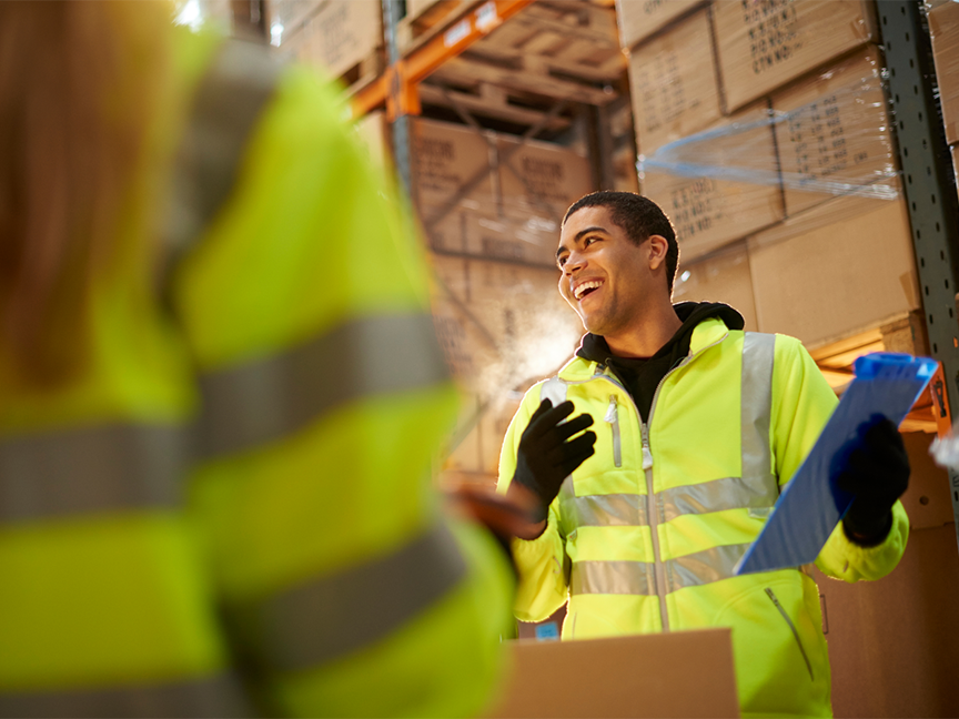 A smiling warehouse worker in a warehouse