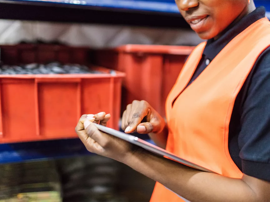 A warehouse worker uses a digital tablet.