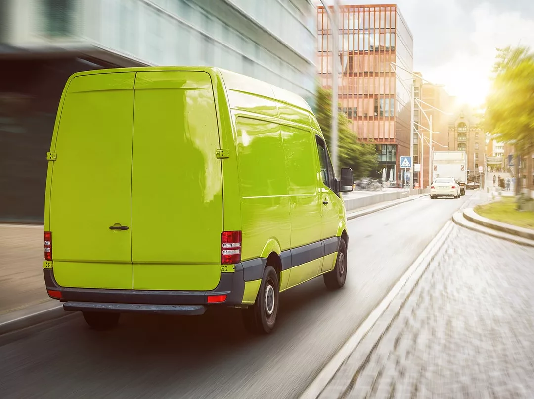 A GREEN DELIVERY VAN DRIVES DOWN A STREET iStock-photoschmidt-1307217489.jpg
