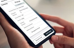 A hand holds a device showing the TECSYS hospital receiving app