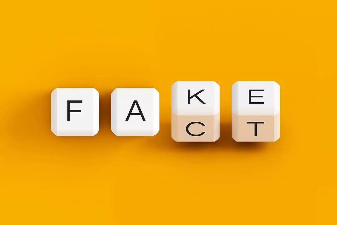 LETTERS ON FOUR DICE TURNING THE LAST TWO LETTERS TO CHANGE THE WORD SPELLEDFROM FAKE TO FACT