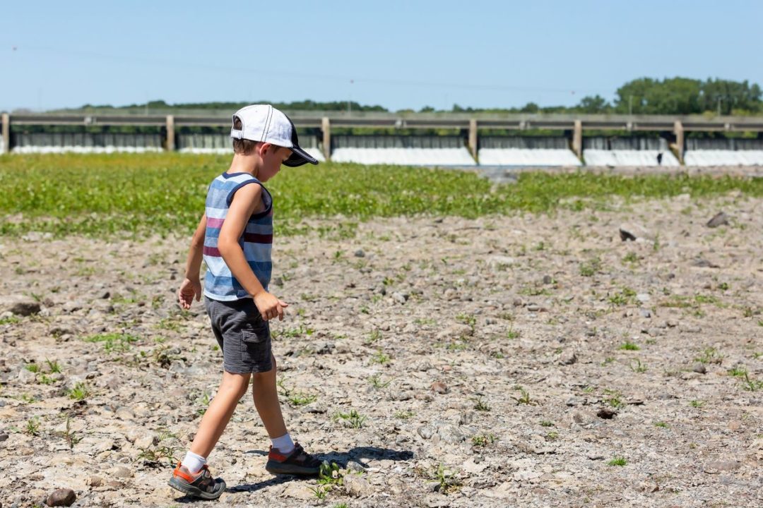 A BOY WALKS ON A DRIED RIVERBED OF THE MISSISSIPPI RIVER