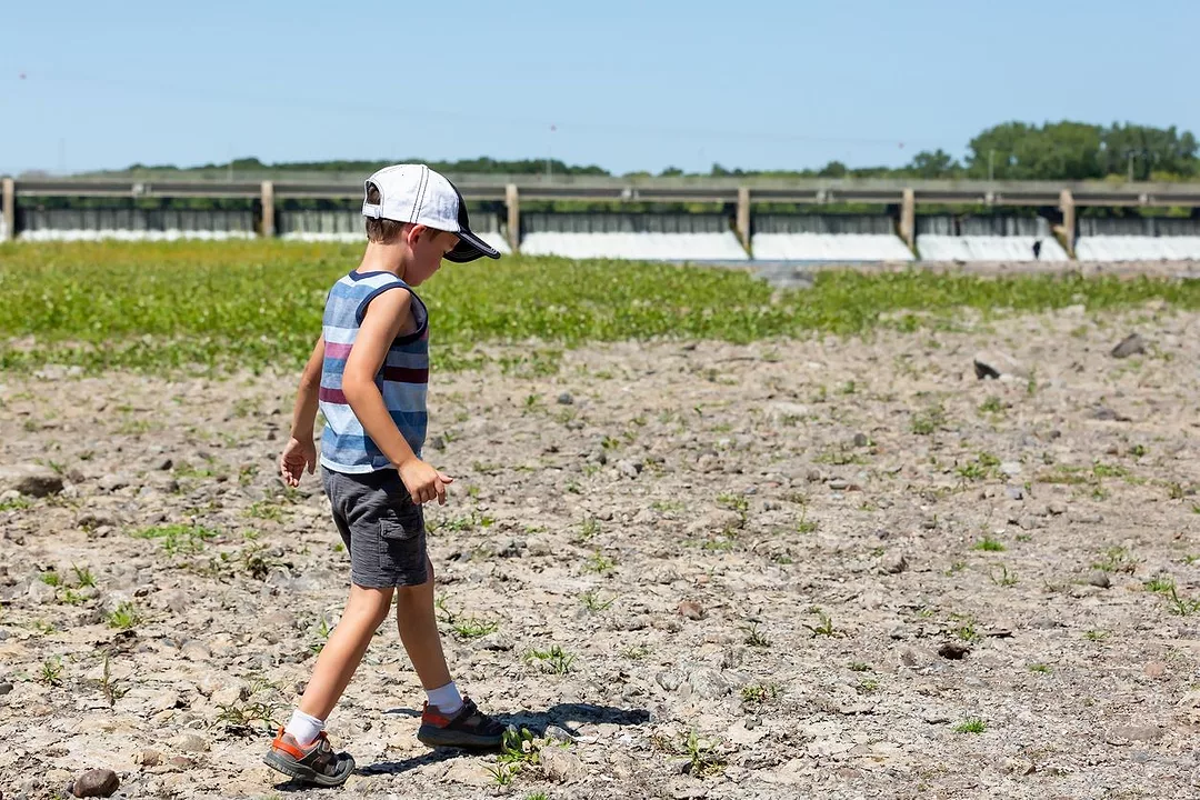 A BOY WALKS ON A DRIED RIVERBED OF THE MISSISSIPPI RIVER