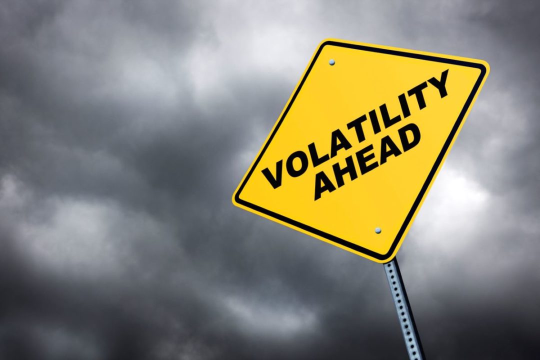 A YELLOW AND BLACK TRAFFIC SIGN THAT READS "VOLATILITY AHEAD"