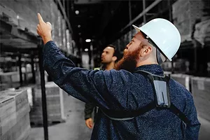 A worker wears a StrongArm sensor while working in a warehouse.