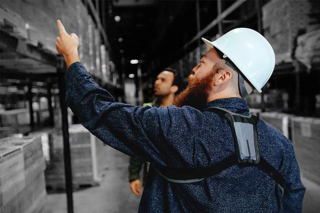 A worker wears a StrongArm sensor while working in a warehouse.