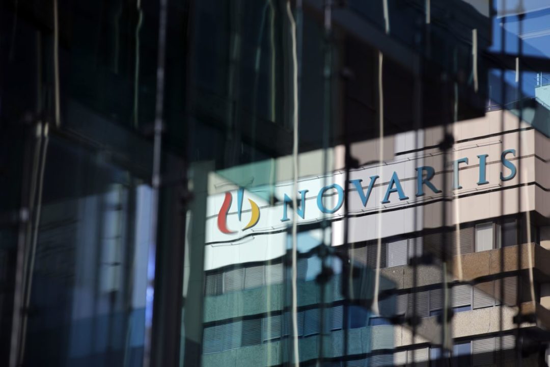 REFLECTIONS OF THE NOVARTIS LOGO IN THE WINDOWS OF AN OFFICE BUILDING