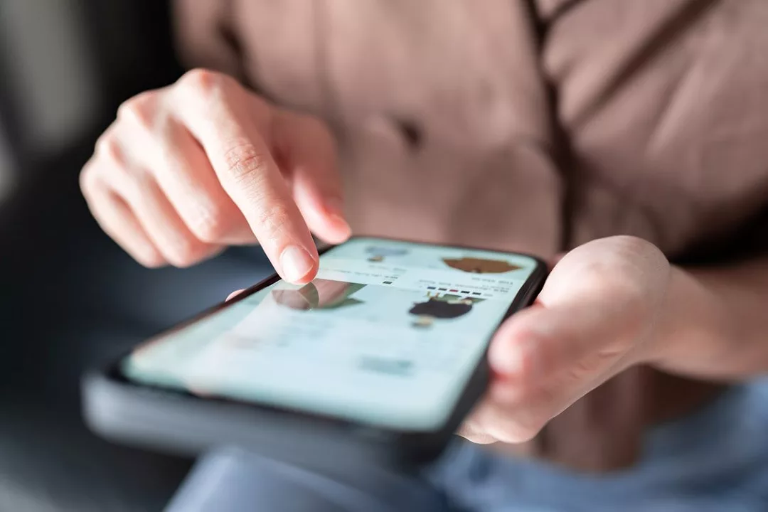 A PERSON SELECTS AN ITEM FOR PURCHASE ON A SMARTPHONE