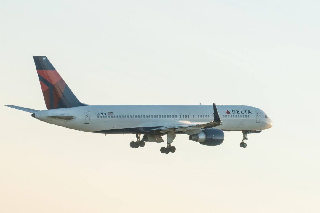 A DELTA 757-200 PLANE FLIES THROUGH THE AIR