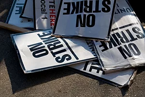 A JUMBLE OF STRIKE SIGNS LIE ON THE GROUND