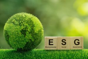 A MODEL OF THE EARTH IN GREEN MOSS SITS NEXT TO WOODEN BLOCKS SHOWING THE LETTERS ESG s609-1341372517.jpg