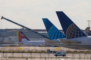 THE TAILS OF UNITED AIRLINES PLANES ON THE TARMAC AT AN AIRPORT