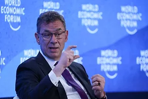 ALBERT BOURLA GESTURES ON STAGE AGAINST A BACKGROUND SAYING WORLD ECONOMIC FORUM
