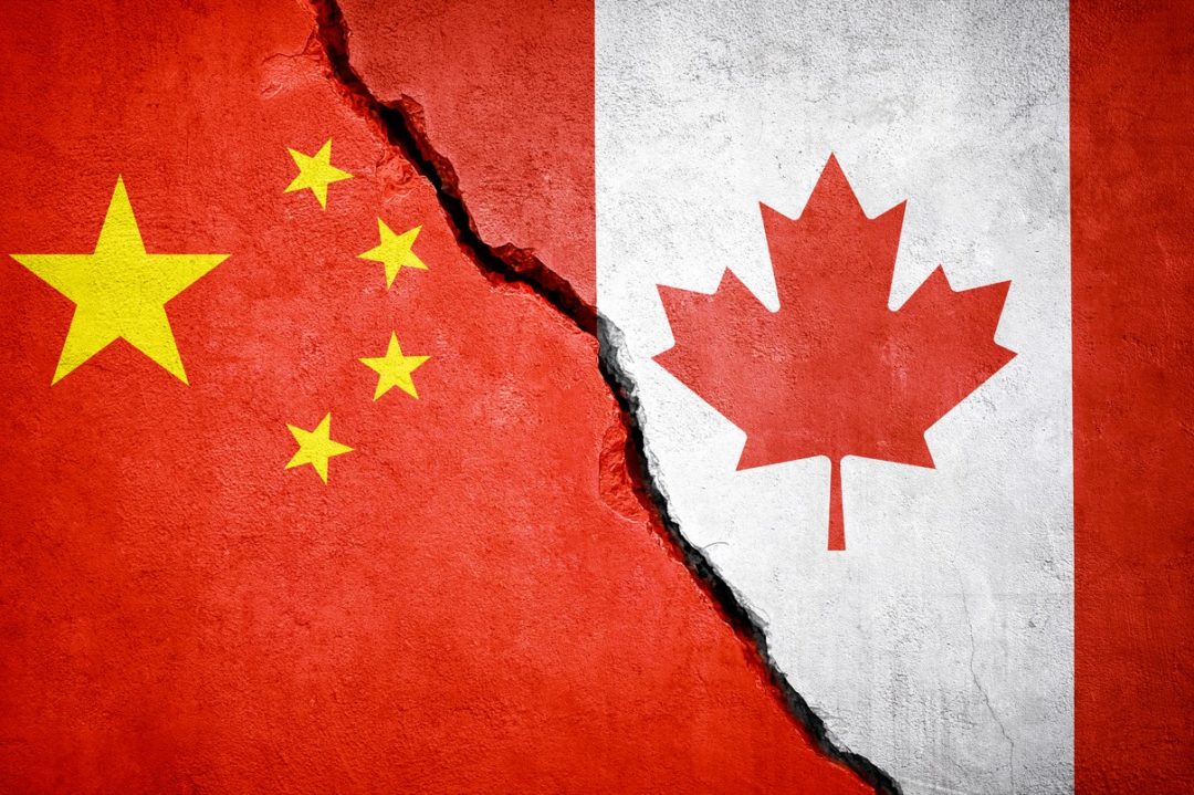 THE FLAGS OF CANADA AND CHINA PAINTED ON CONCRETE, WITH A RIFT BETWEEN THE TWO