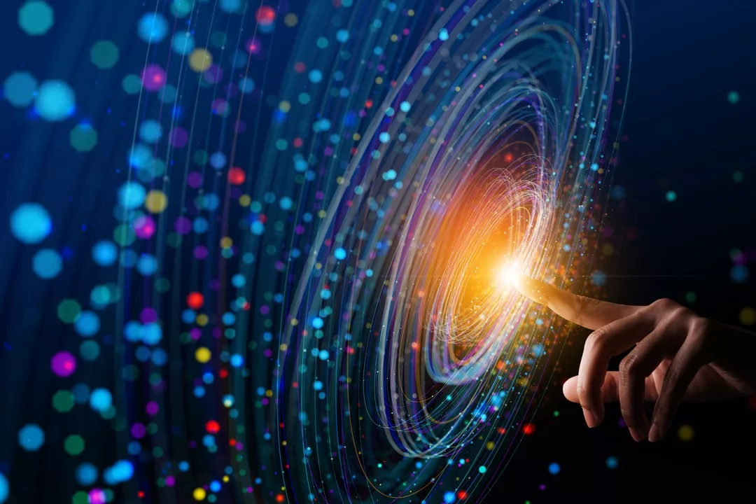 A HAND PUTS AN EXTENDED FINGER INTO A SWIRLING WHORL OF LIGHTS