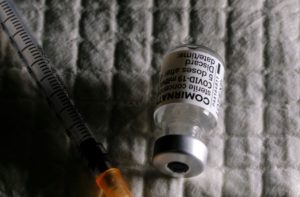 A PHIAL OF BioNTech'S COMIRNATY VACCINE LIES NEXT TO A SYRINGE