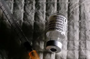 A PHIAL OF BioNTech'S COMIRNATY VACCINE LIES NEXT TO A SYRINGE