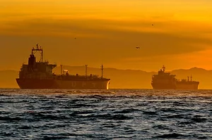 OIL TANKERS AT SEA IN THE SUNSET