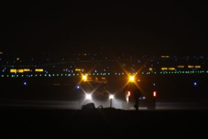 LIGHTS SCATTERED AROUND AN AIRPORT AT NIGHT 