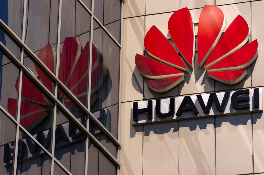 THE HUAWEI COMPANY LOGO IS DISPLAYED AND REFLECTED IN THE GLASS EXTERIORI OF AN  OFFICE BUILDING 