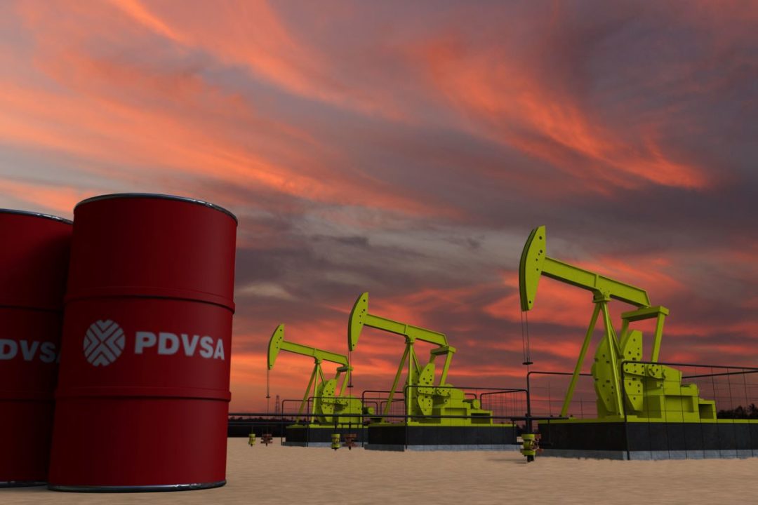 OIL BARRELS BEARING THE PDVSA LOGO SIT NEXT TO OIL DERRICKS AGAINST A SUNSET