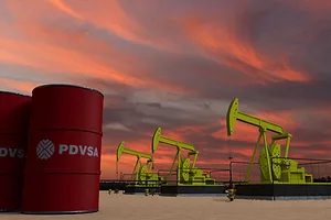OIL BARRELS BEARING THE PDVSA LOGO SIT NEXT TO OIL DERRICKS AGAINST A SUNSET
