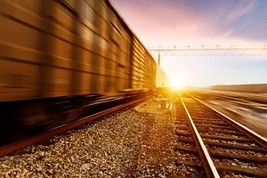 A TRAIN RIDES A RAIL INTO THE SUNSET
