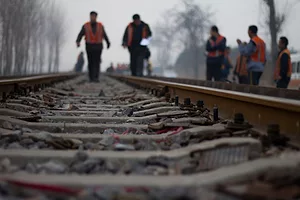 RAIL WORKERS WORK ON A STRETCH OF RAIL TRACK