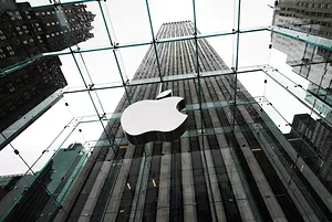 THE EXTERIOR OF AN APPLE OFFICE, THE COMPANY LOGO REFLECTED IN GLASS