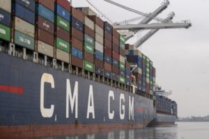 A SIDE VIEW OF A CMA CGM CONTAINER SHIP AT DOCK