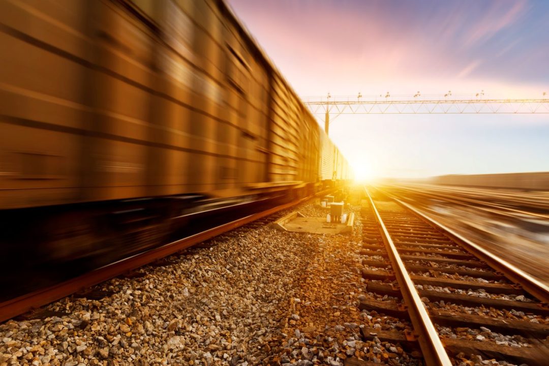 A TRAIN ON A TRACK HEADS INTO THE SUN