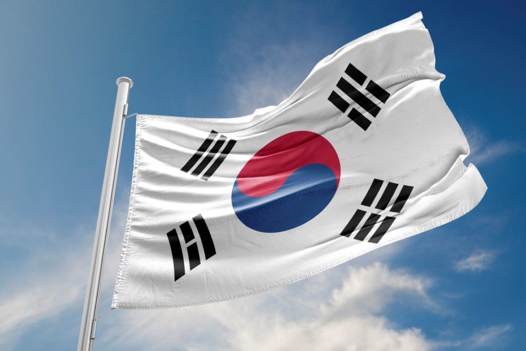 THE FLAG OF SOUTH KOREA FLIES AGAINST A BLUE SKY