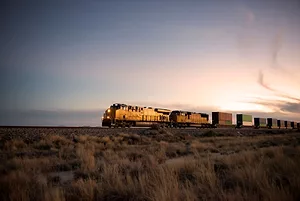 A TRAIN RIDES THE RAILS AT DUSK
