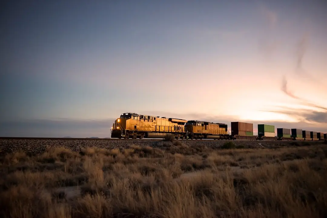 A TRAIN RIDES THE RAILS AT DUSK