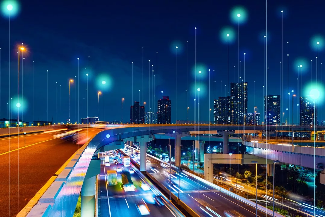 A CITYSCAPE AT NIGHT, WITH LIGHTED SKYSCRAPERS AND A GLOWING HIGHWAY, BRIGHT LINES OF CONNECTION DARTING EVERYWHERE