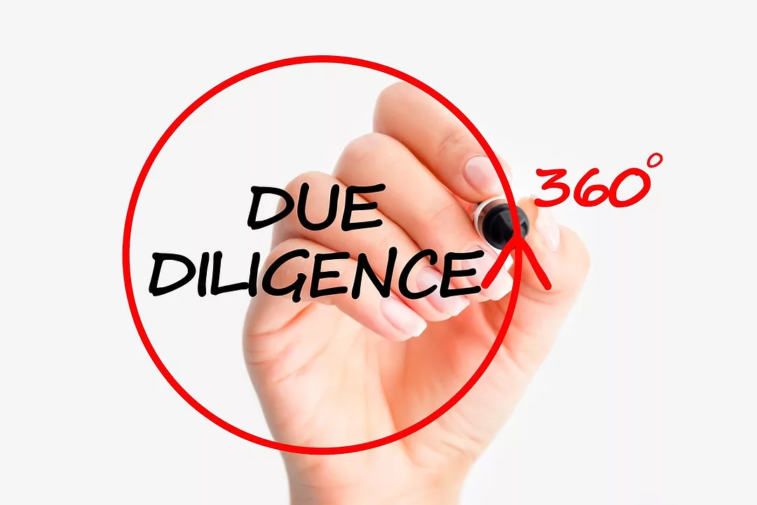 A HAND DRAWS A RED CIRCLE ON GLASS, WITH THE WORDS DUE DILIGENCE 360 IN THE MIDDLE