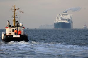 A LARGE TANKER APPROACHES A TUG ON THE HIGH SEAS