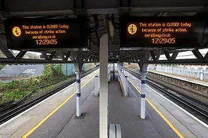 SIGNS READING THIS STATION IS CLOSED TODAY ABOVE EMPTY TRAIN STATION PLATFORMS