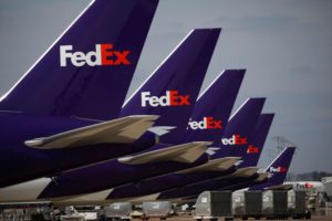 A LINE OF PLANS BEARING THE FEDEX LOGO ON THEIR TAILS SITS ON THE TARMAC