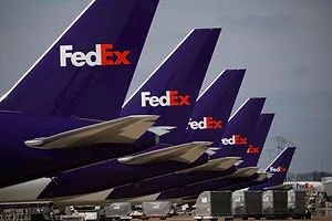 A LINE OF PLANS BEARING THE FEDEX LOGO ON THEIR TAILS SITS ON THE TARMAC