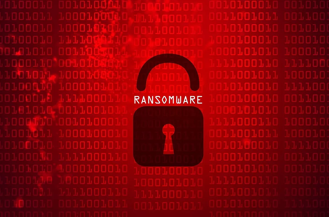 A GLOWING RED SCREEN SHOWSCOMPUTER BITS AND BYTES, WITH THE WORD RANSOMWARE AT THE CENTER