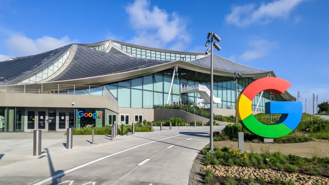 A PAVILION-STYLE ONE-STORY OFFICE BUILDING STANDS IN SUNSHINE, THE GOOGLE LOGO VISIBLE.