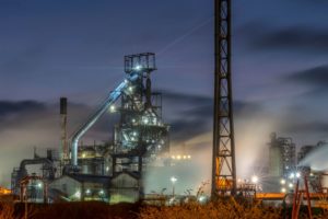 A STEEL MILL, RESPLENDENT WITH TOWERS AND PIPES, GLOWS IN THE NIGHT