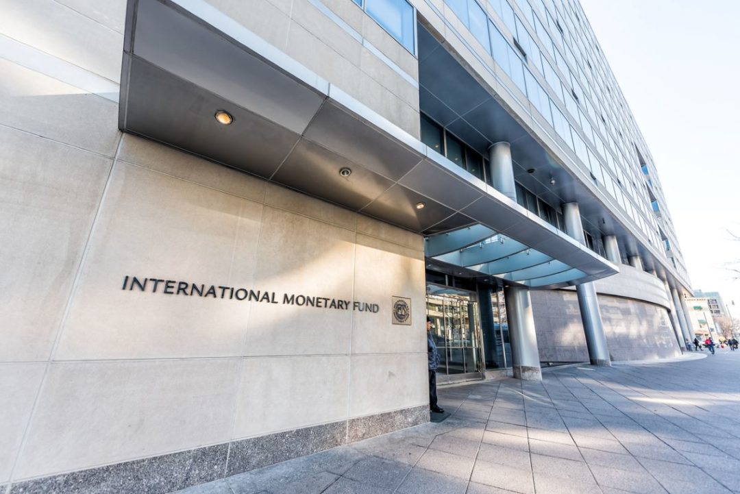 A SIDEWALK-LEVEL SHOT OF A LARGE OFFICE BUILDING BEARING THE WORDS INTERNATIONAL MONETARY FUND