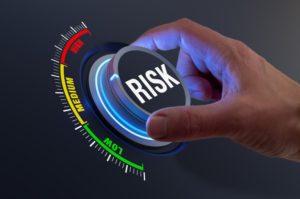 A HAND TURNS A LARGE, LIGHTED DIAL WITH THE WORD RISK ON IT iStock-NicoElNino-1364371014.jpg