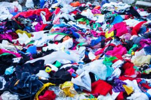 A HUGE TRASH PILE OF DISCARDED CLOTHES ARE ALL JUMBLED UP TOGETHER