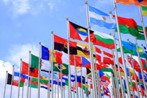 FLAGS OF MANY NATIONS FLUTTER IN THE BREEZE AGAINST A CLEAR BLUE SKYges-179243711.jpg