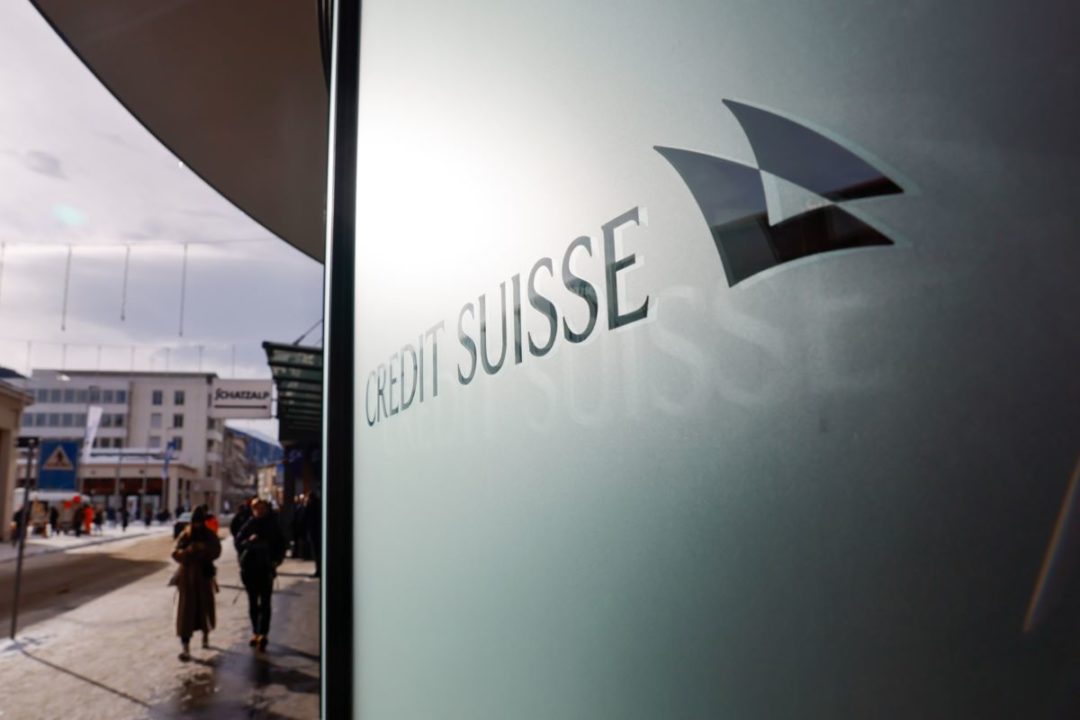 PEDESTRIANS WALK OUTSIDE THE FROSTED GLASS OF A CREDIT SUISSE OFFICE