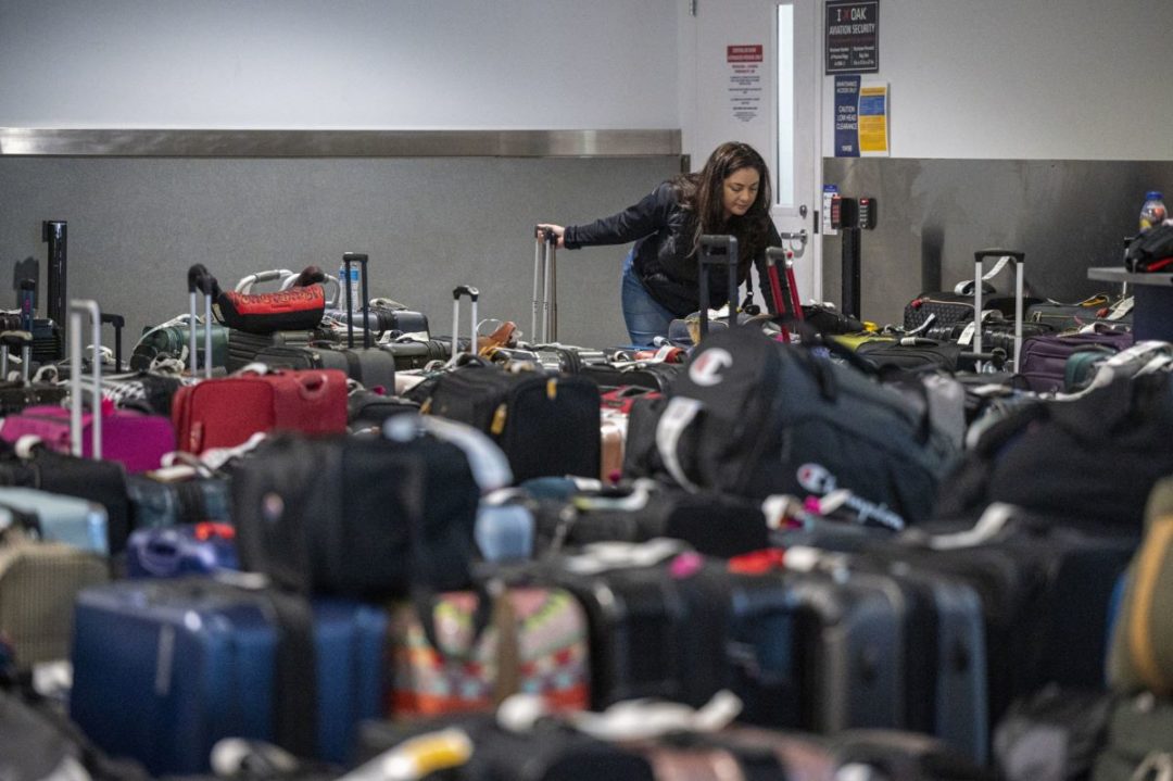 A WOMAN SEEN AT THE FAR END OF A SEA OF LUGGAGE